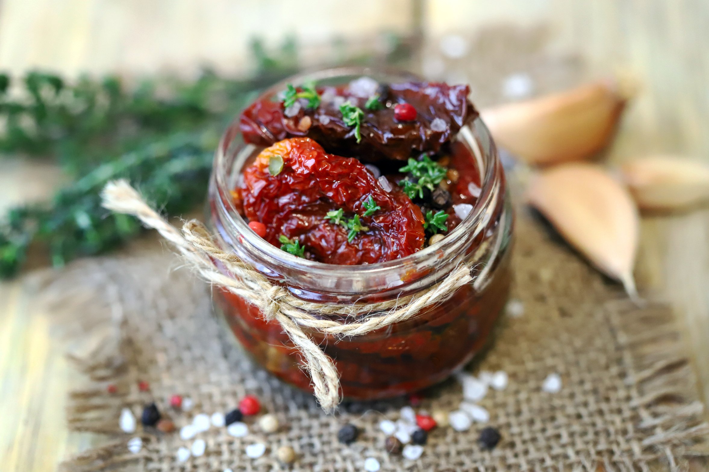 Soft focus. Macro. A jar of sun-dried tomatoes with thyme and spices.