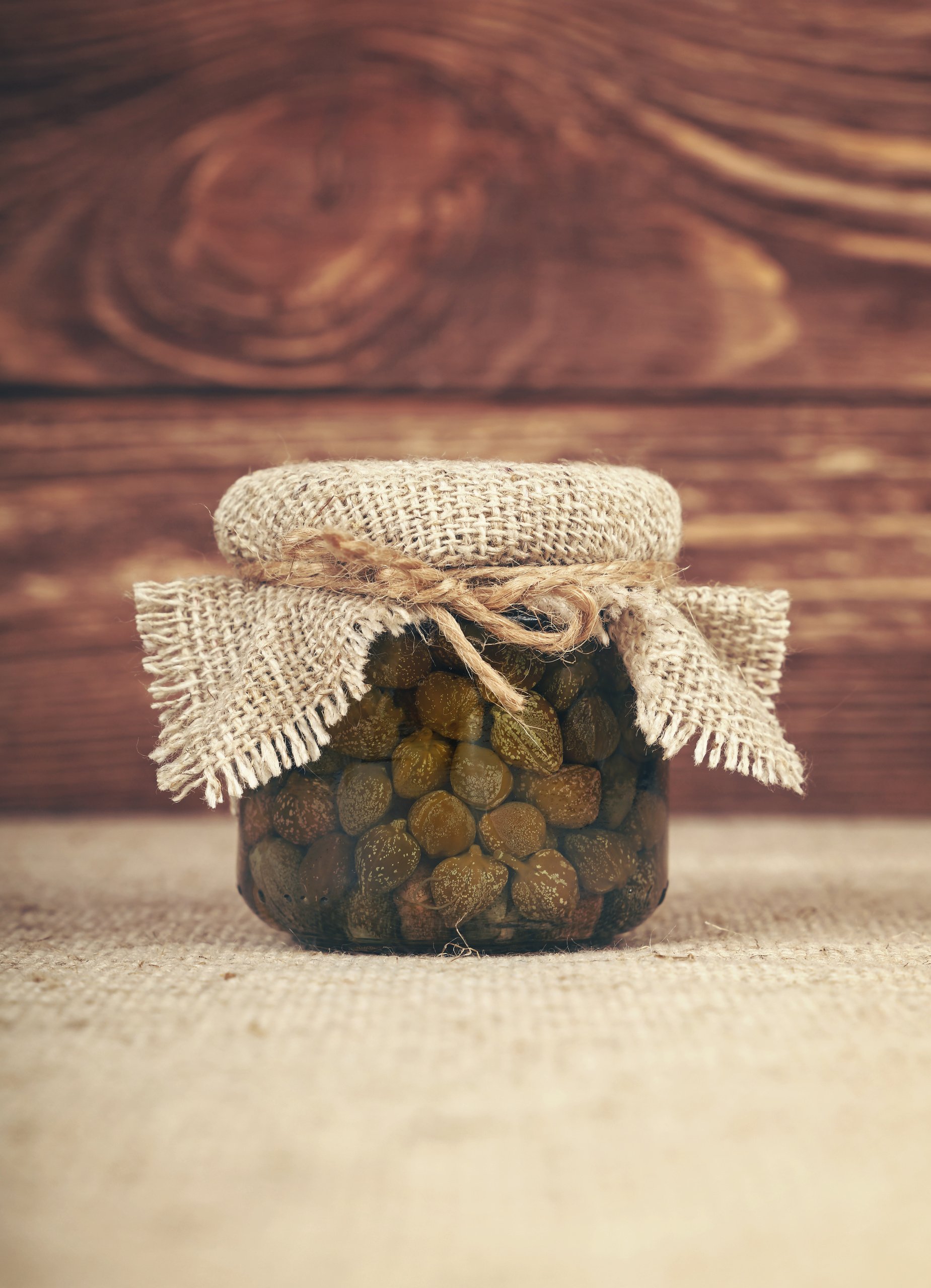 Close-Up Of Capers In Jar On Table